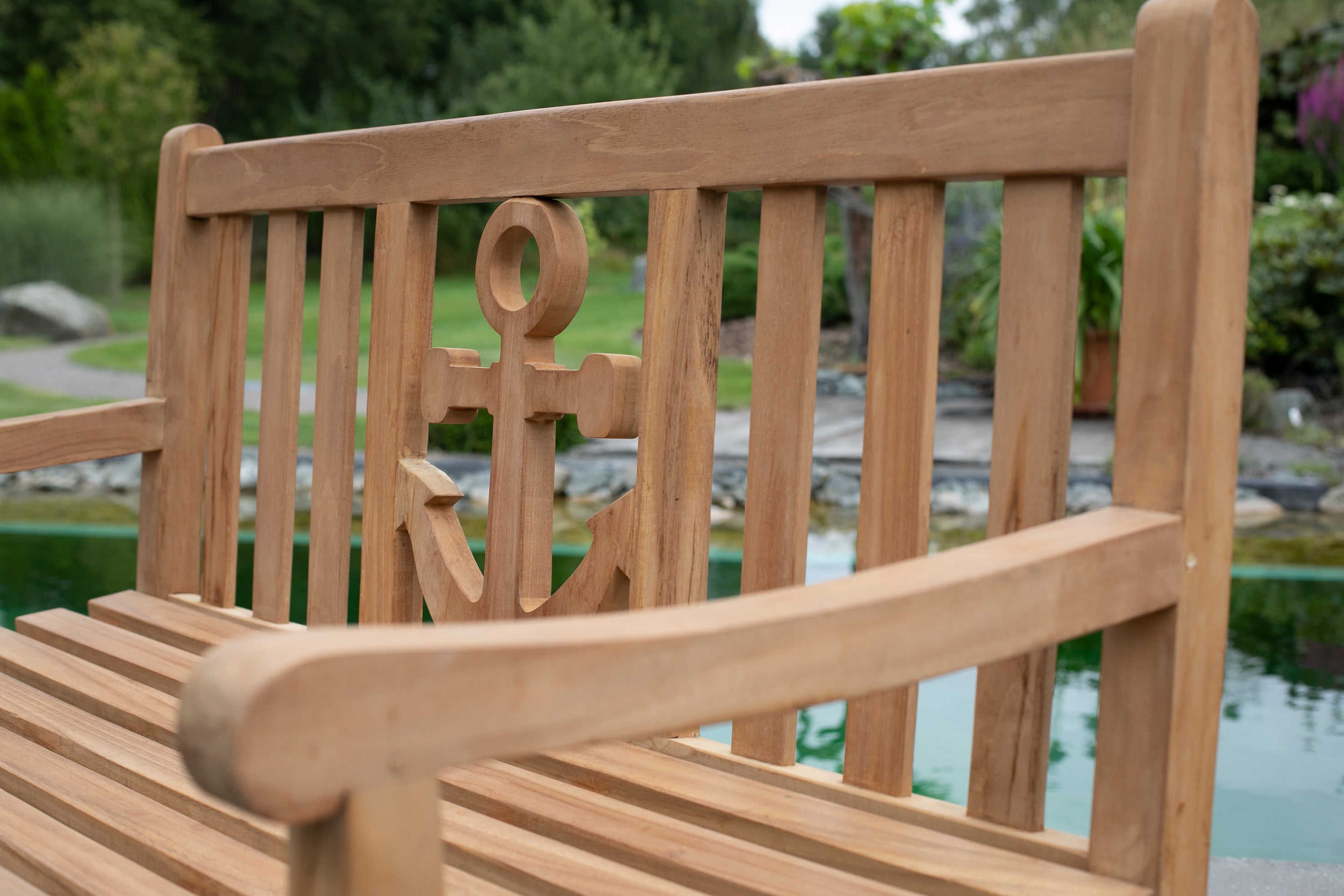 Die Teak-Gartenbank Anker aus massivem Naturholz mit Anker-Rückenlehne ist die perfekte Sitzgelegenheit zum Entspannen am Teich in Ihrem Garten.