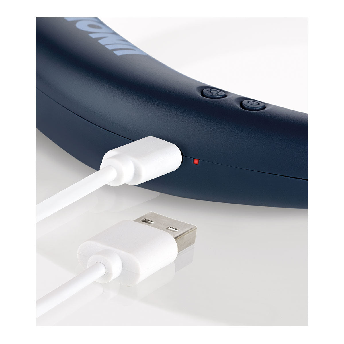 Nahaufnahme eines weißen USB-Ladekabels, das an den Nackenventilator Breezy angeschlossen ist, mit Tasten, Optionen zur Geschwindigkeitsregelung und einer kleinen roten Kontrollleuchte.