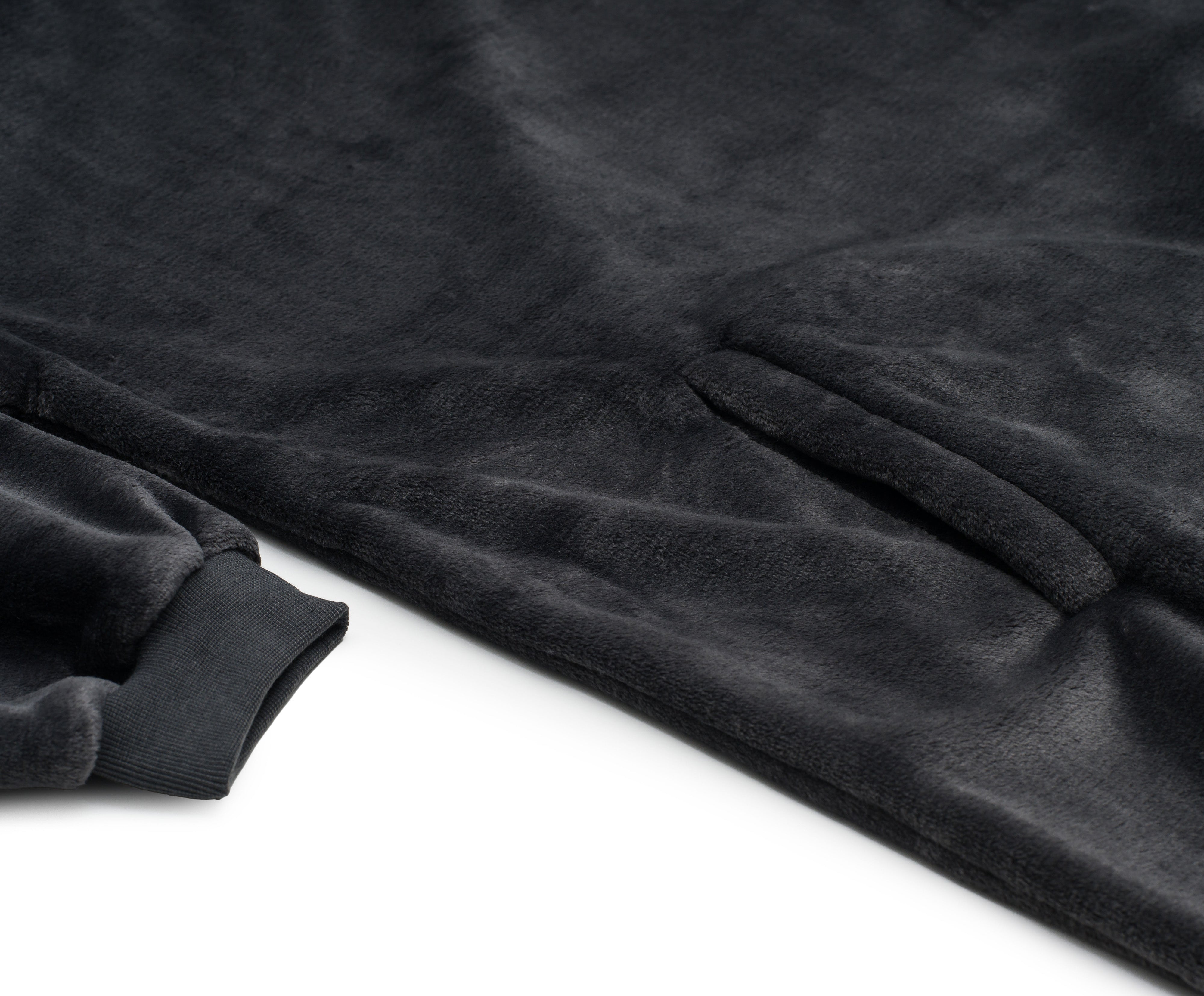 Nahaufnahme eines schwarzen Hoodies mit Kapuze aus Mikrofaser-Fleece mit Tasche und geripptem Bündchen auf weißem Hintergrund, der das gemütliche Gefühl einer Kuscheldecke in Universalgröße bietet.