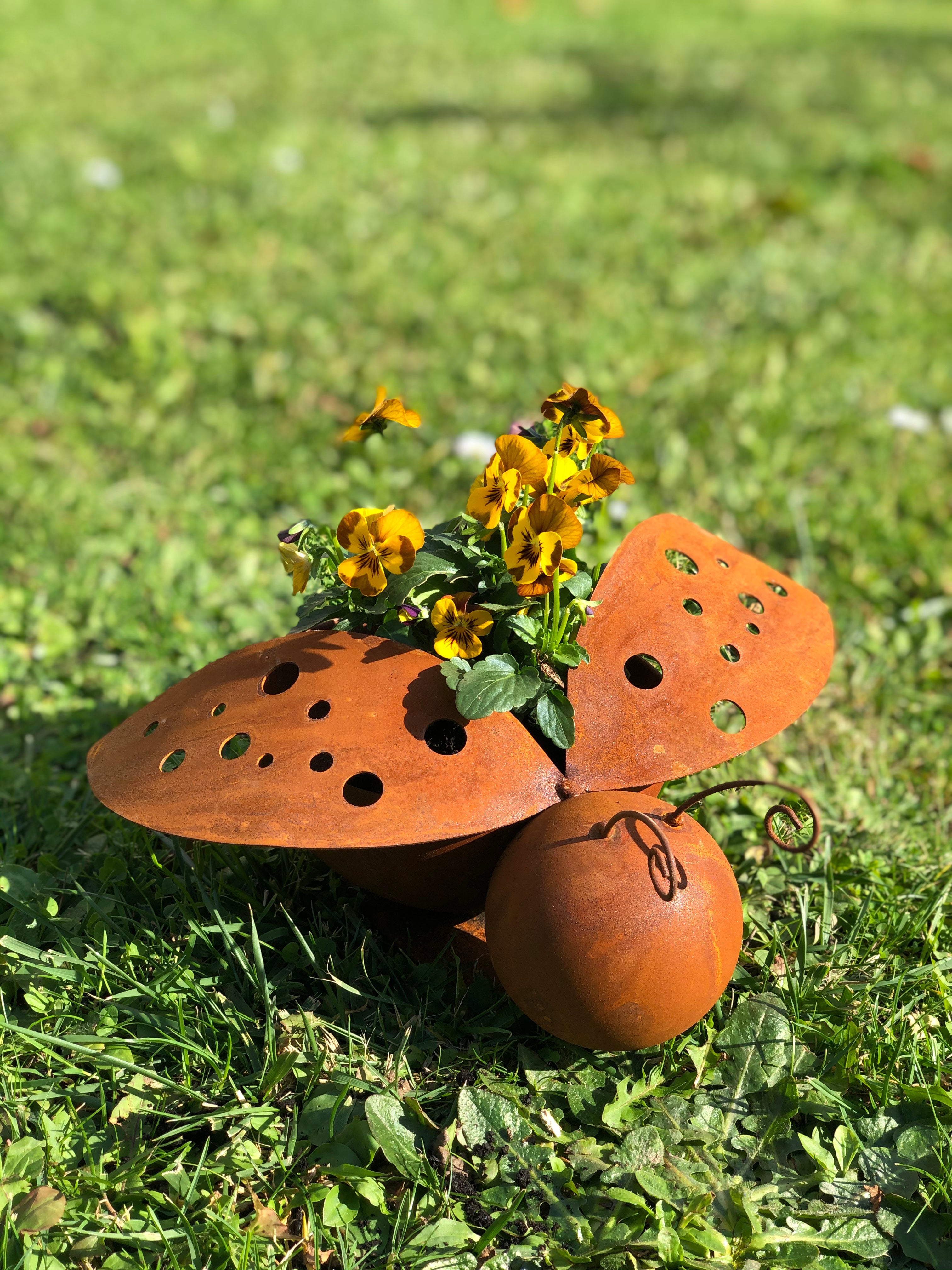 Das Edelrost Marienkäfer 2er-Set verleiht Ihrem Garten als dekoratives Highlight rustikalen Charme – zwei Marienkäfer aus Metall in Edelrost-Optik, die sich perfekt auf grünem Gras oder zwischen gelben Blumen im Sonnenlicht präsentieren.
