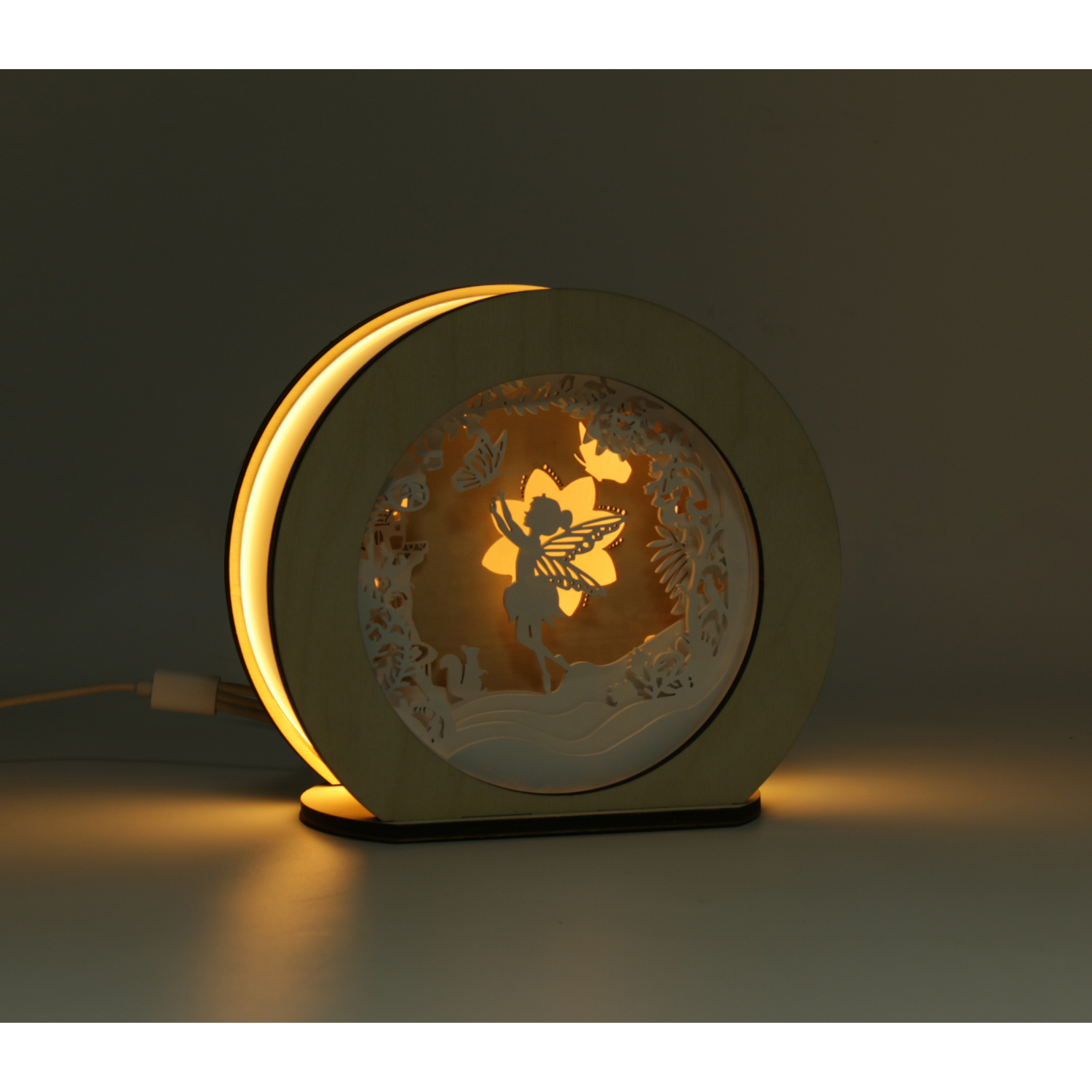 Die Magic Light 3D Holz-Nachtlampe Fee besticht durch ihr rundes, dekoratives Feen- und Blumendesign. Dank LED-Technologie erhellt sie jeden dunklen Raum mit sanftem, zauberhaftem Licht.
