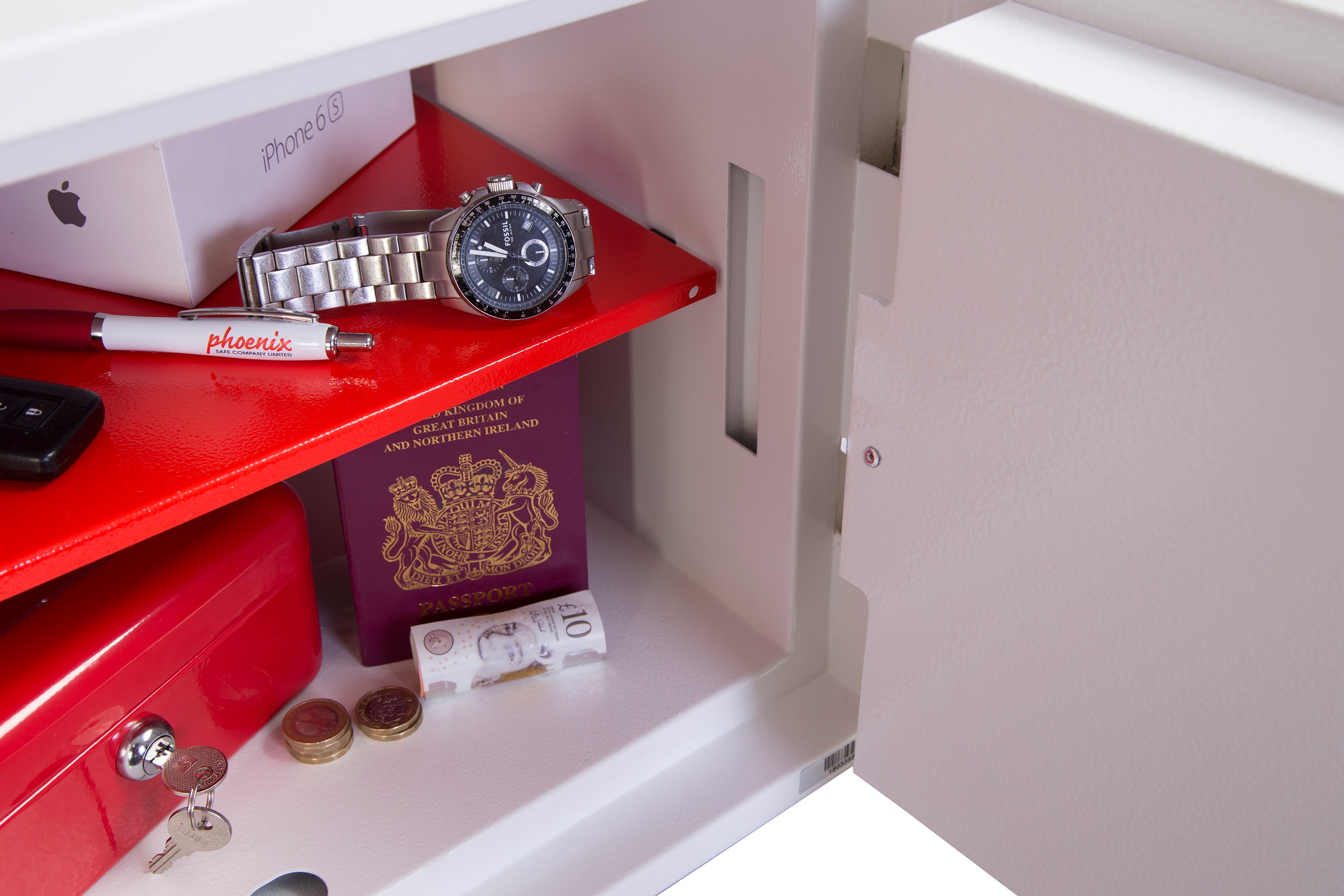Offener Sicherheitstresor mit Uhr, Reisepass, Kugelschreiber, Telefonzelle, Geld und Münzen auf roten und weißen Regalen – perfekt für höchste Einbruchsicherheit.