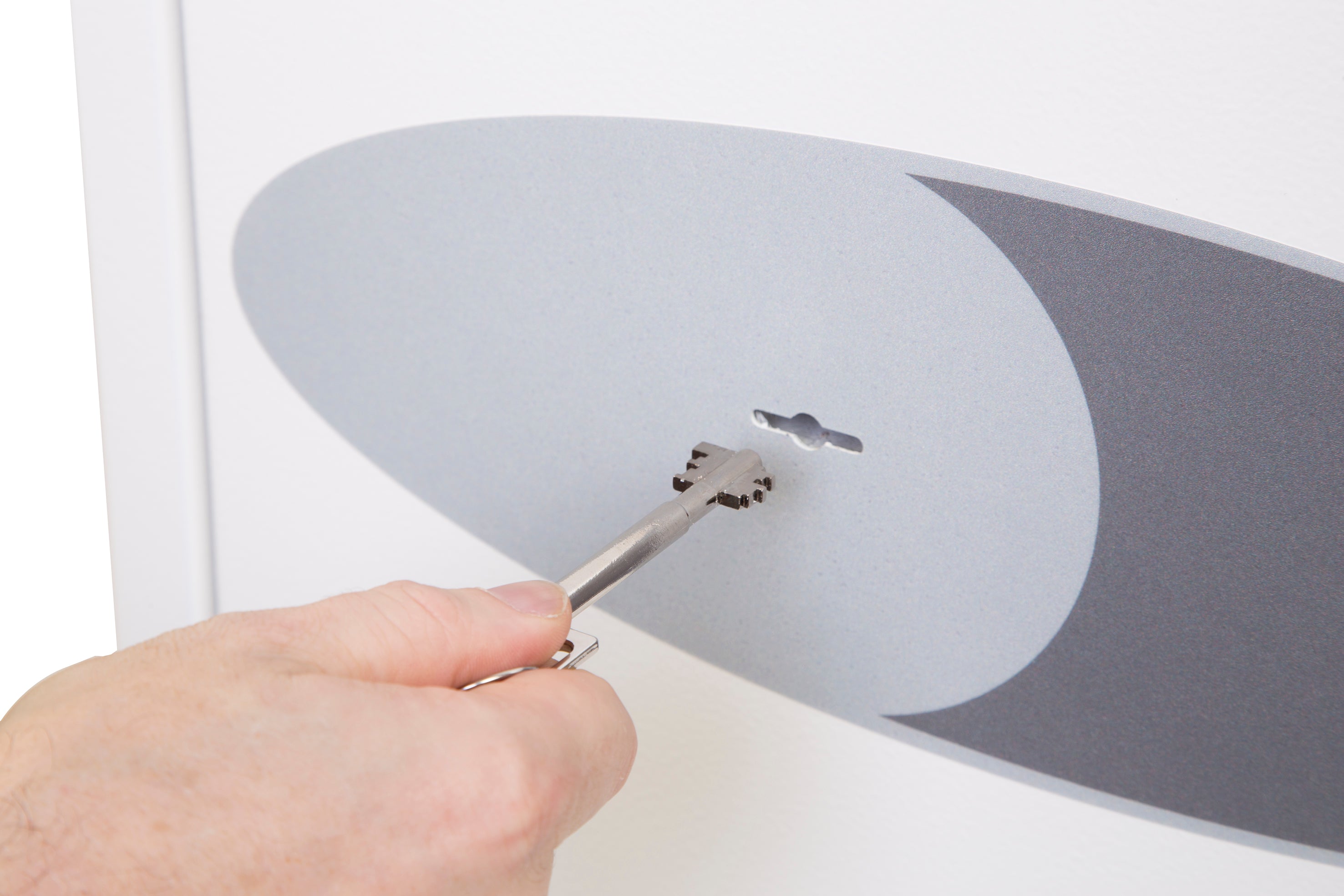 Eine Hand steckt einen Schlüssel in das Schlüsselloch eines weiß-grauen Sicherheitstresors und hebt dessen fortschrittliche Schutzfunktionen hervor.