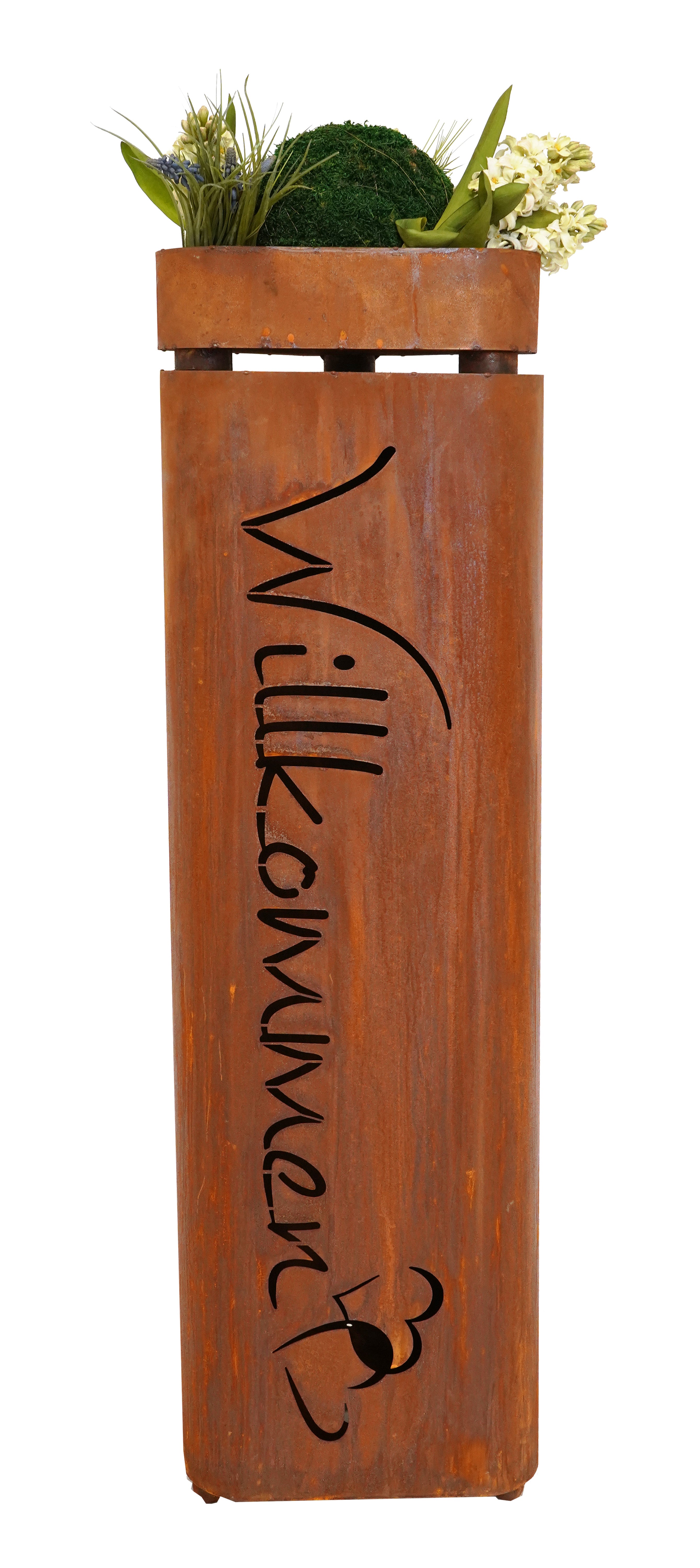 Die Edelrost Pflanzsäule Willkommen mit Schale ist ein hoher rostfarbener Pflanzkasten aus Metall mit „Willkommen“-Aussparung, witterungsbeständig und frostsicher, mit grünen Pflanzen und weißen Blumen auf der Oberseite.