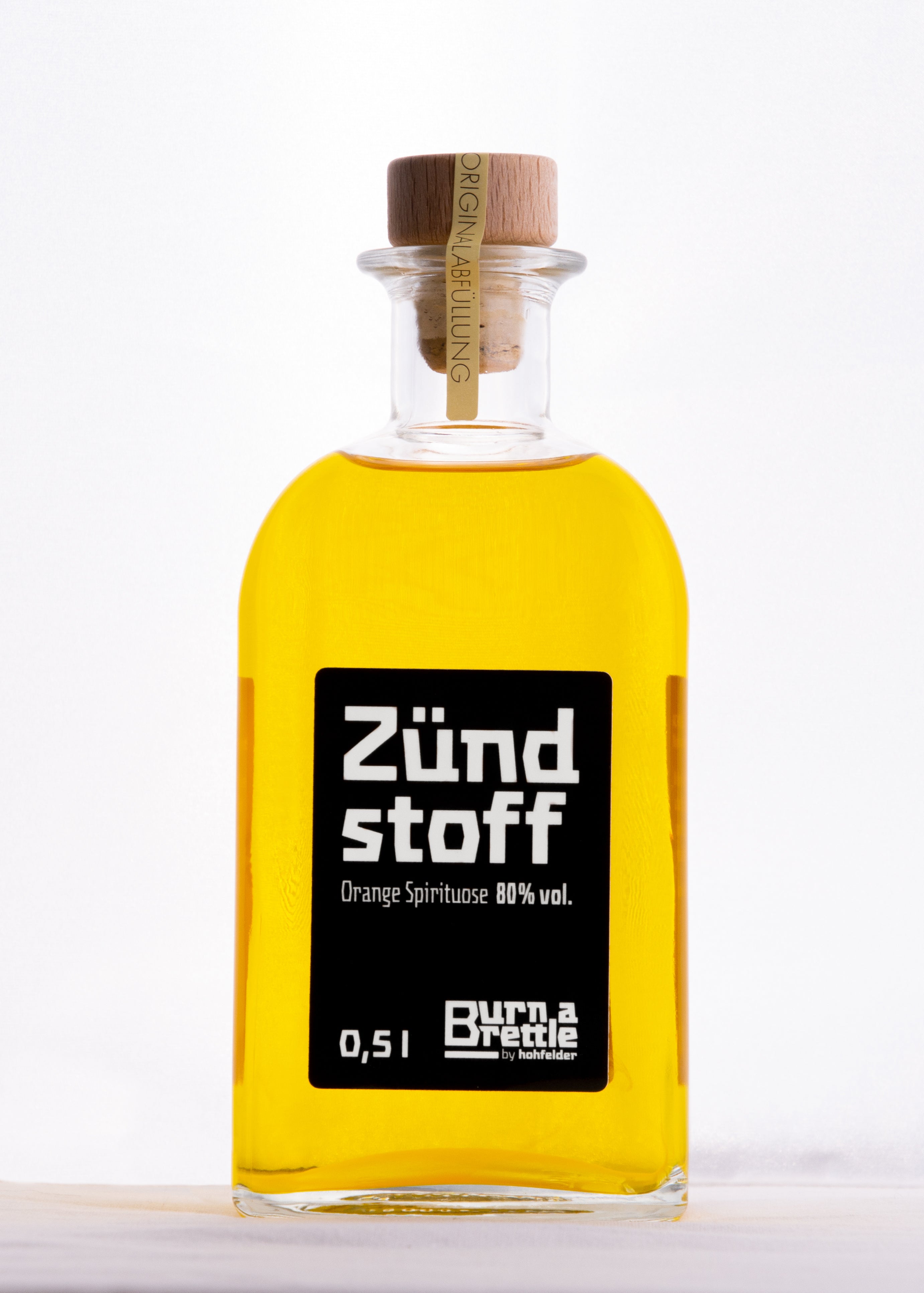 „Burn a Brettle Zündstoff“ ist eine klare Glasflasche, gefüllt mit Orangenspirituosen mit 80 % Vol. – ideal, um kräftige Geschmackserlebnisse zu entfachen.