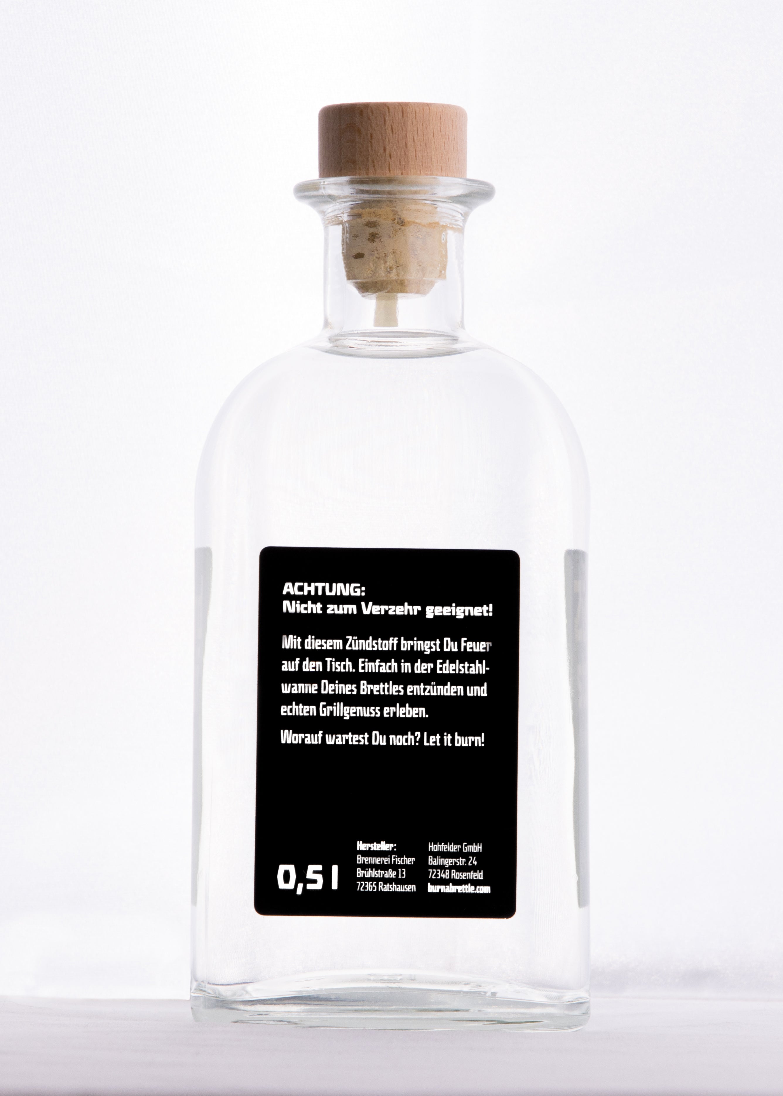 Klare Glasflasche mit Korken und schwarzem Etikett mit deutschem Warntext auf weißem Hintergrund – ideal zum Präsentieren von „Burn a Brettle Zündstoff“ oder zum Hervorheben einzigartiger Geschmacksorten in Ihrer Sammlung.