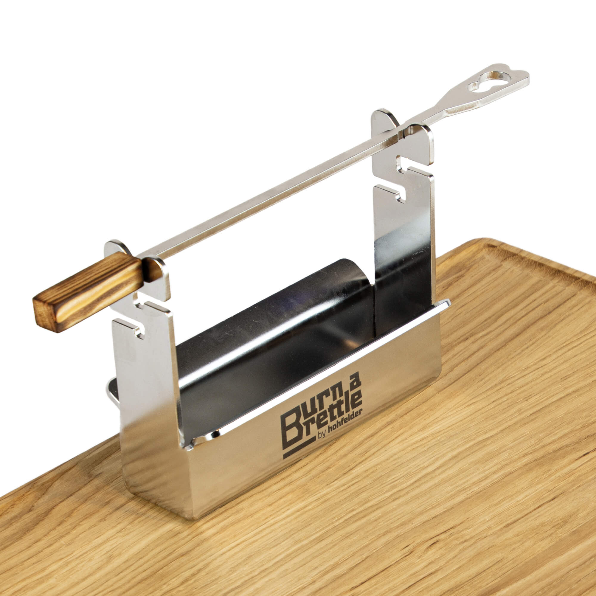 Ein Werkzeug aus Metall und Holz mit einer Rolle und einem Griff, genannt „Burn a Brettle“, gefertigt aus nachhaltigen Materialien, abgebildet auf einer Holzoberfläche.