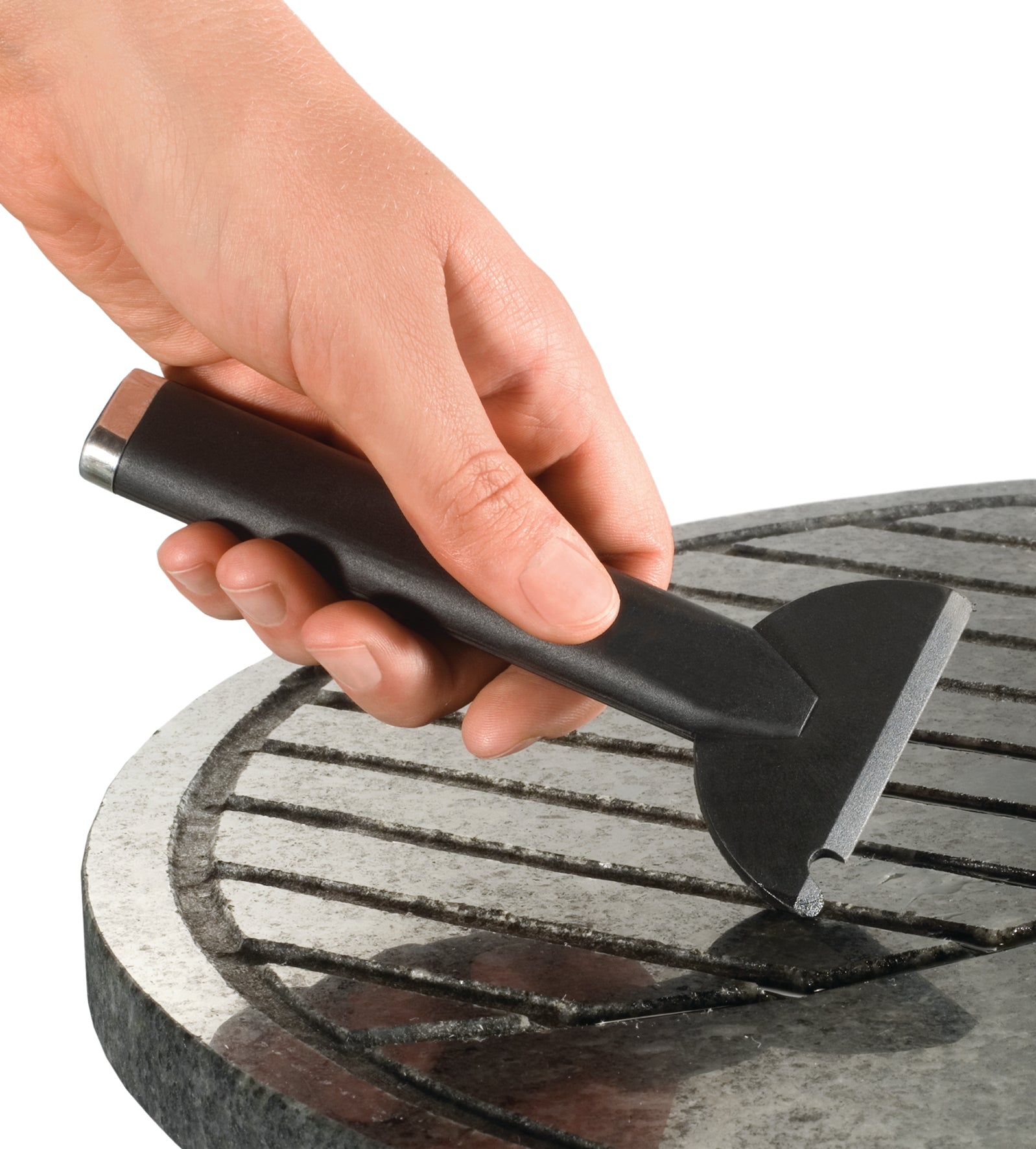 Eine Hand reinigt den Grillrost mit einem Grillschaber und macht ihn bereit für den Einsatz mit Raclette 4in1, Fondue, Grill.